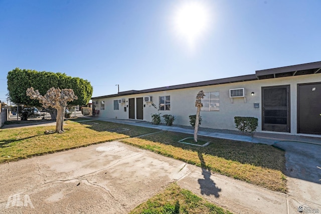 single story home featuring a front lawn and a patio