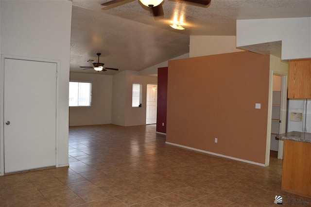 unfurnished living room featuring vaulted ceiling and ceiling fan