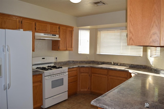 kitchen with sink, light tile patterned flooring, and white appliances