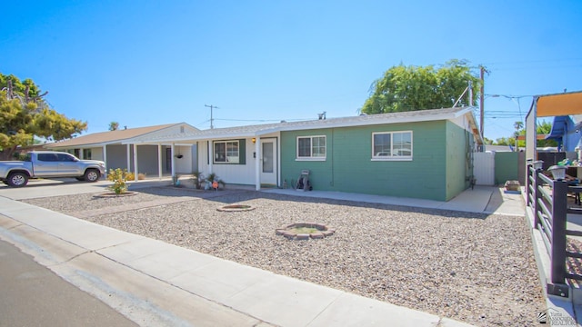 ranch-style house featuring a carport, fence, and concrete driveway