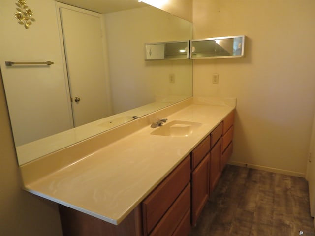 bathroom featuring vanity, wood finished floors, and baseboards