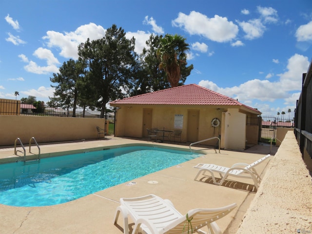 pool with a patio and fence