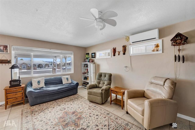 sitting room with light tile patterned floors, a textured ceiling, a wall mounted AC, and ceiling fan