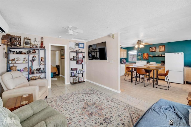 living room with light tile patterned floors, a textured ceiling, and ceiling fan