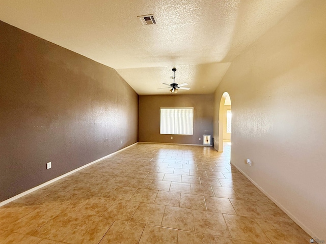 unfurnished room with a textured ceiling, vaulted ceiling, ceiling fan, and light tile patterned flooring