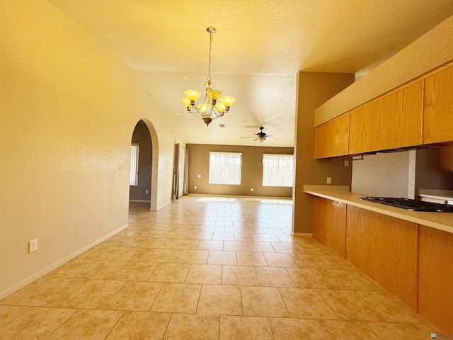 kitchen featuring ceiling fan with notable chandelier, black gas cooktop, decorative light fixtures, light tile patterned floors, and a textured ceiling