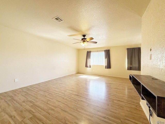 unfurnished living room with ceiling fan, a textured ceiling, and light wood-type flooring