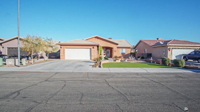 view of front of house featuring a garage, driveway, and stucco siding