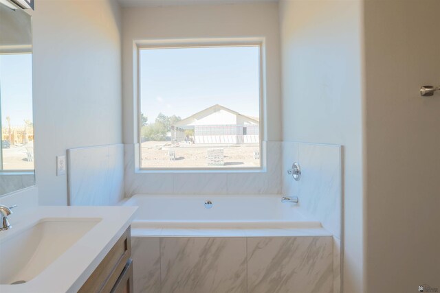 bathroom with vanity and tiled bath