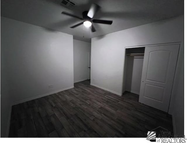 unfurnished bedroom featuring ceiling fan, dark wood-type flooring, and a closet