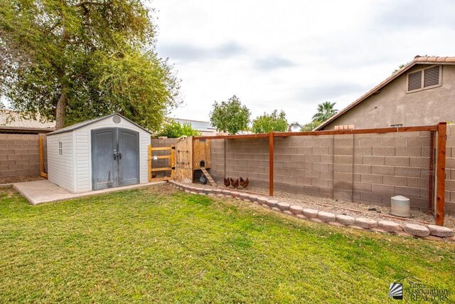 view of yard with an outbuilding, a shed, and a fenced backyard