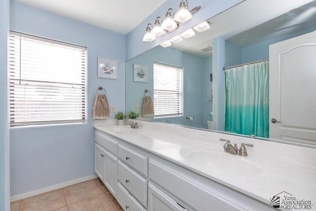 full bathroom featuring toilet, a sink, tile patterned flooring, double vanity, and baseboards