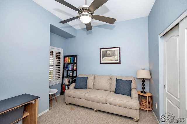 carpeted living area with a ceiling fan and baseboards