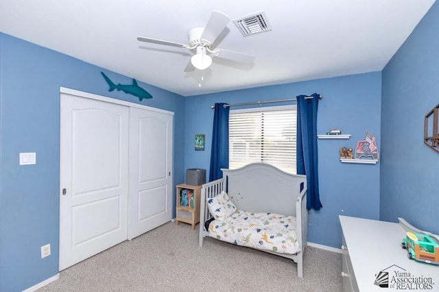 carpeted bedroom with baseboards, visible vents, a closet, and ceiling fan