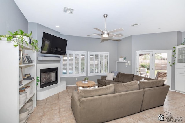 tiled living area featuring a glass covered fireplace, recessed lighting, a ceiling fan, and visible vents