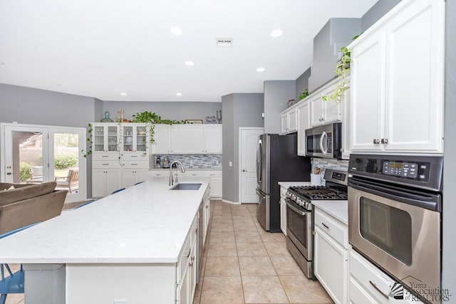 kitchen featuring a sink, white cabinets, backsplash, and stainless steel appliances