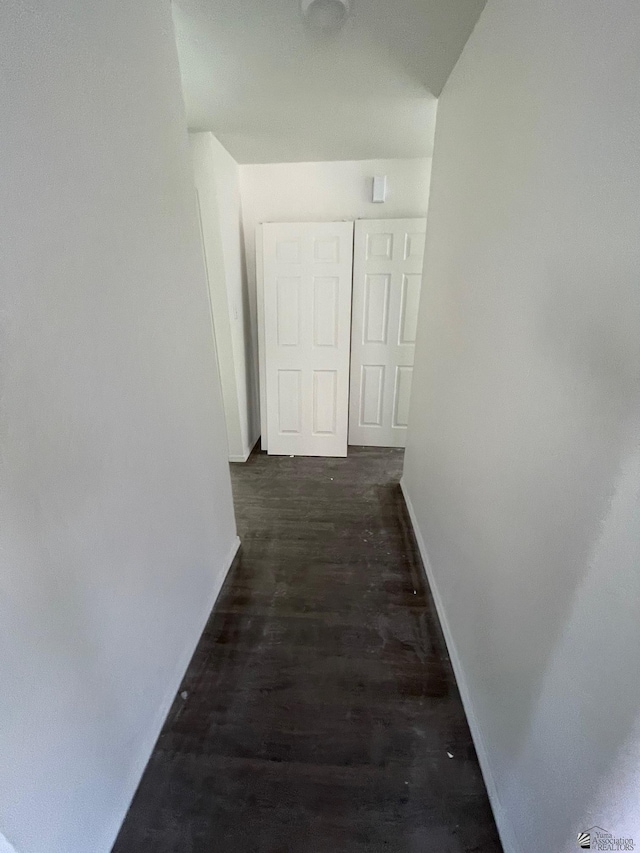 corridor with dark hardwood / wood-style flooring