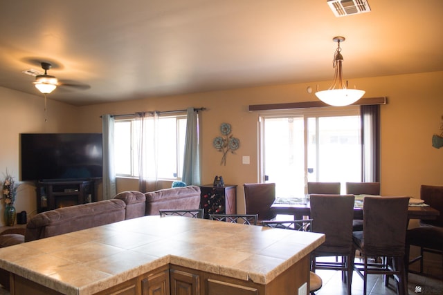 kitchen featuring visible vents, open floor plan, plenty of natural light, and tile counters