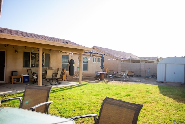 view of yard with a patio area, fence, an outdoor structure, and a shed