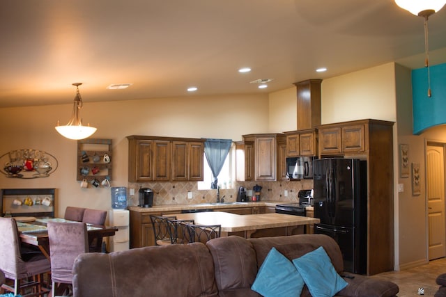 kitchen with decorative backsplash, black appliances, light countertops, decorative light fixtures, and open floor plan