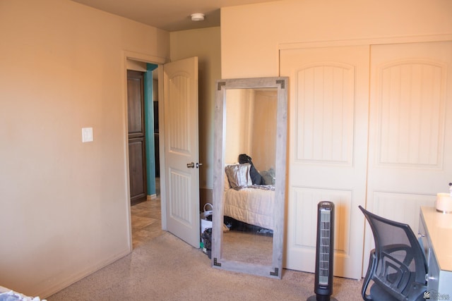 carpeted bedroom with a closet and baseboards