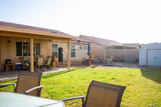 view of yard with a patio, fence, a shed, outdoor dining area, and an outdoor structure