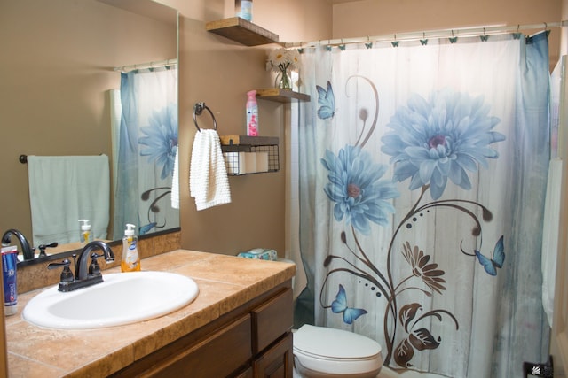 bathroom featuring toilet, vanity, and a shower with curtain