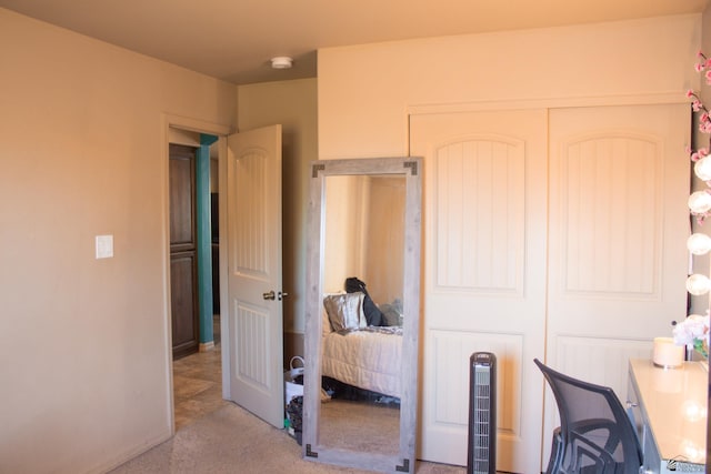 carpeted bedroom featuring baseboards and a closet