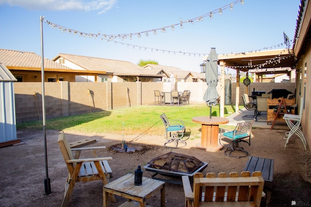 view of patio with a fire pit, a fenced backyard, and outdoor dining space