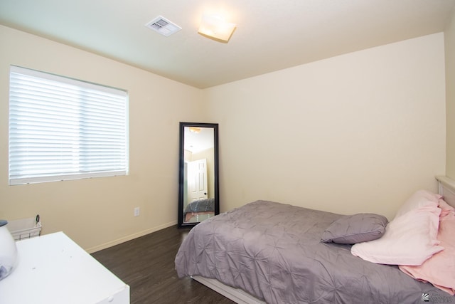 bedroom featuring dark wood-type flooring, visible vents, and baseboards