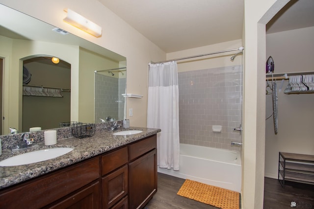 bathroom with shower / bath combo with shower curtain, visible vents, a sink, and wood finished floors