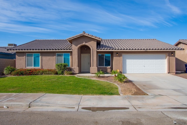 view of front of house with driveway, an attached garage, a front yard, and stucco siding