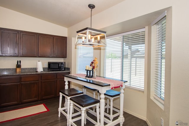 kitchen featuring dark countertops, dark wood finished floors, dark brown cabinetry, and a notable chandelier