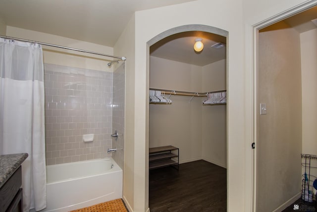 full bathroom featuring visible vents, shower / bathtub combination with curtain, a spacious closet, vanity, and baseboards