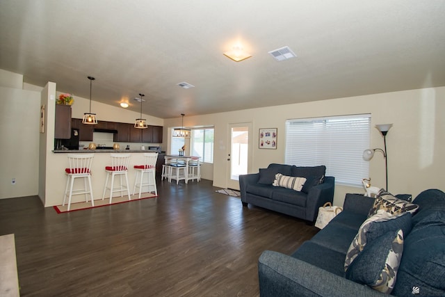 living area featuring lofted ceiling, dark wood-style floors, and visible vents