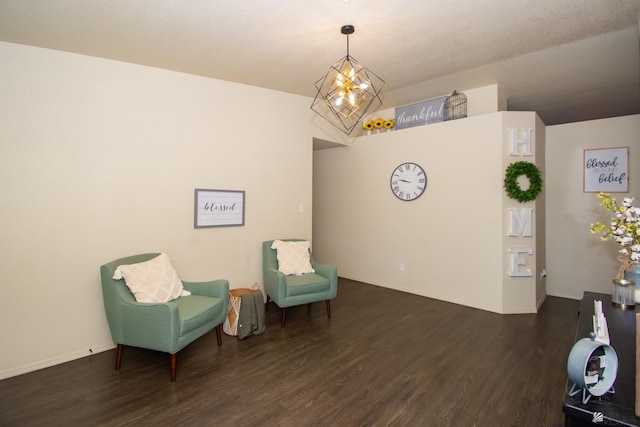 living area with an inviting chandelier, baseboards, and wood finished floors