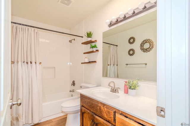 bathroom featuring visible vents, toilet, wood finished floors, shower / tub combo with curtain, and vanity