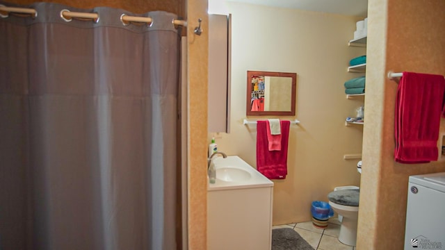 bathroom with toilet, vanity, washer / clothes dryer, and tile patterned floors