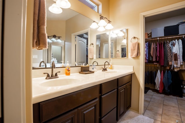 full bathroom featuring a sink, a spacious closet, double vanity, and tile patterned floors