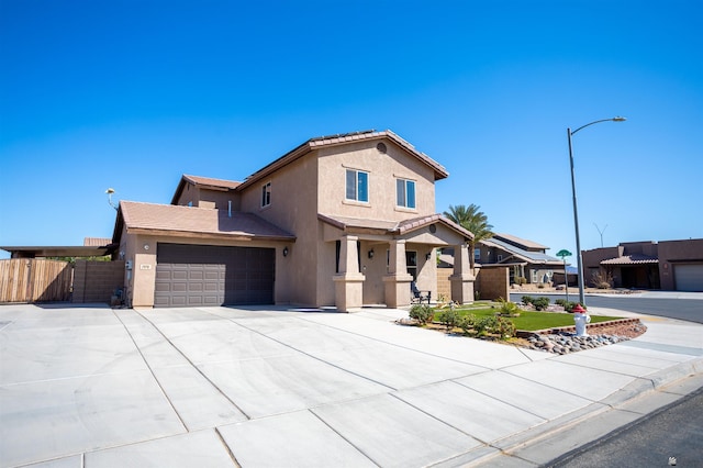 view of front of property featuring stucco siding, fence, concrete driveway, an attached garage, and a tiled roof