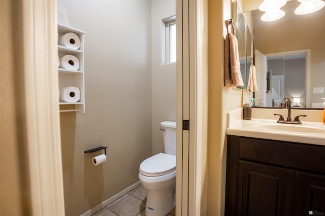 bathroom with baseboards, toilet, vanity, and tile patterned flooring