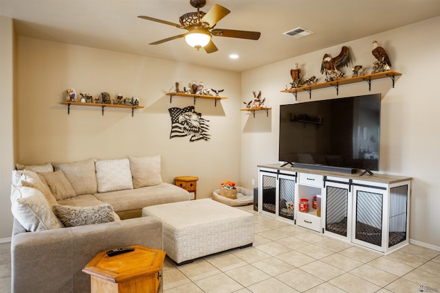 living area with light tile patterned flooring, visible vents, baseboards, and ceiling fan