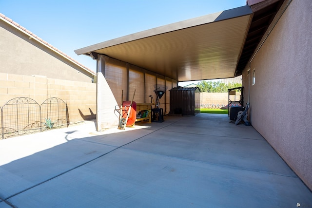 view of parking / parking lot with an attached carport and fence