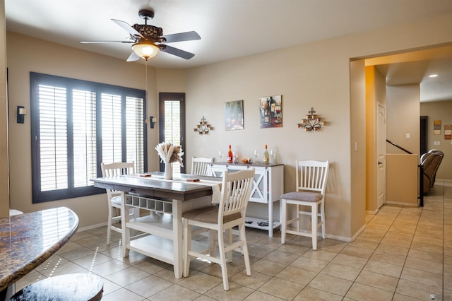 dining room with baseboards, ceiling fan, and tile patterned flooring