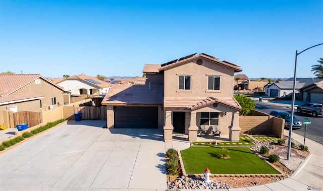 mediterranean / spanish house featuring a residential view, a tile roof, roof mounted solar panels, and fence