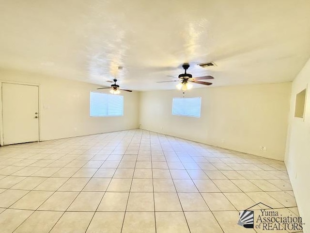 tiled empty room featuring ceiling fan