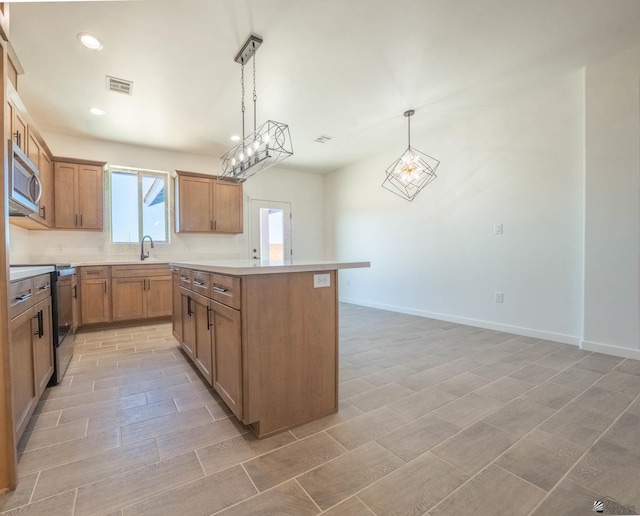 kitchen featuring sink, a chandelier, decorative light fixtures, a kitchen island, and range