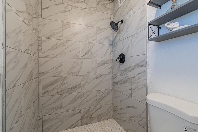 bathroom featuring toilet and tiled shower