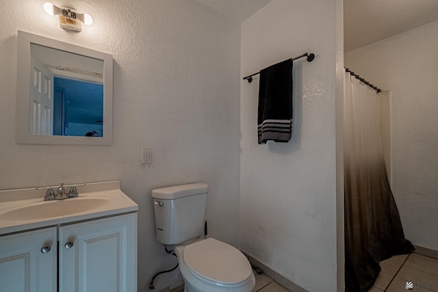 bathroom with tile patterned flooring, vanity, and toilet