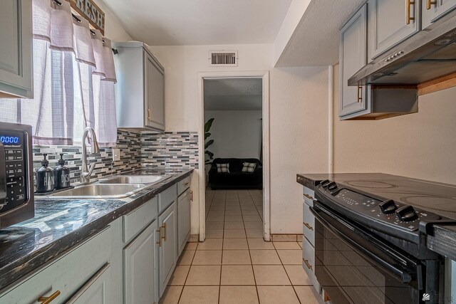 kitchen featuring gray cabinetry, backsplash, sink, light tile patterned floors, and black range with electric cooktop